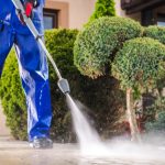 Worker Cleaning Residential Driveway